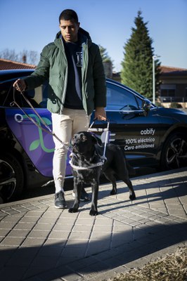 Usuario de perro guía al descender de un vehículo de Cabify