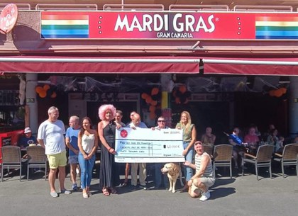 Foto de familia durante el acto de entrega de la donación por parte de los propietarios del pub Mardi Gras
