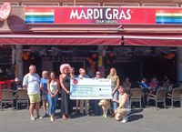 Foto de familia durante el acto de entrega de la donación por parte de los propietarios del pub Mardi Gras