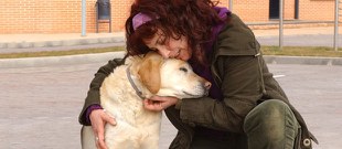 Una adoptante abraza a su perro guía jubilado