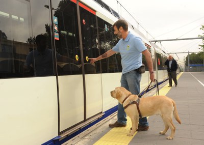 Un instructor entra en el metro con un perro en adiestramiento